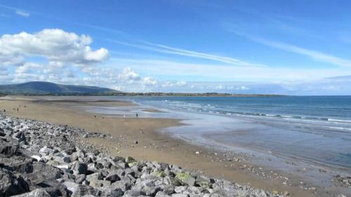 a beach with a bunch of rocks and the ocean at Old Fort Lodge in Sligo