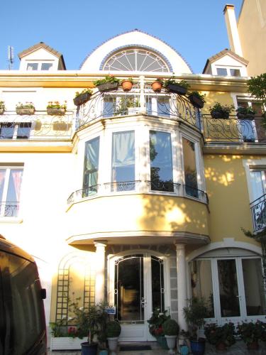 un grand bâtiment blanc avec un balcon dans l'établissement Le studio Chez Marilé, à Bry-sur-Marne