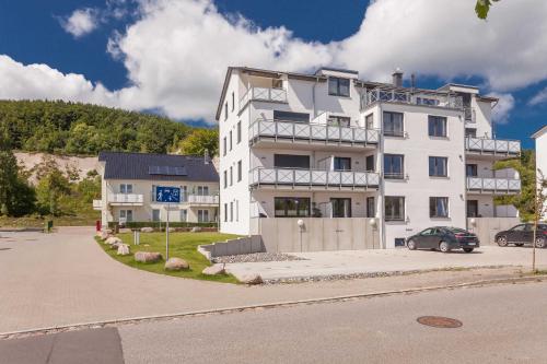 ein weißes Gebäude mit einem davor geparkt in der Unterkunft Villa Am alten Kreidebruch, Penthouse *Sea Spirit* in Sassnitz