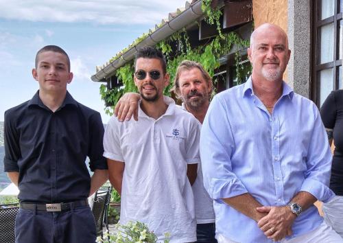 a group of men standing in front of a building at Resort Le Picchiaie in Portoferraio