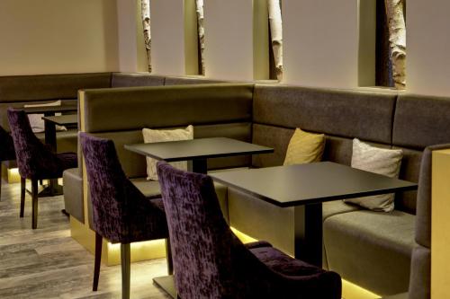 a restaurant with two tables and chairs and a couch at Burlington Hotel, BW Premier Collection by Best Western in Folkestone