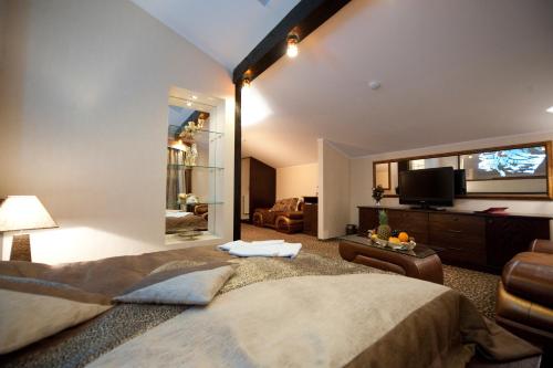 a bedroom with a large bed and a tv at Deluxe Hotel Kupava in Lviv