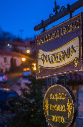 a sign for a moroccan restaurant on the side of a street at Ξενώνας Φιλοξενία 1 & 2 in Palaios Agios Athanasios