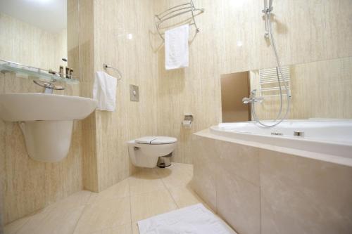 a bathroom with a sink and a toilet and a shower at Deluxe Hotel Kupava in Lviv