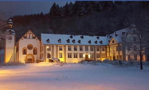 a large white building with a snow covered roof at Gästehaus der Abtei Sayn in Bendorf