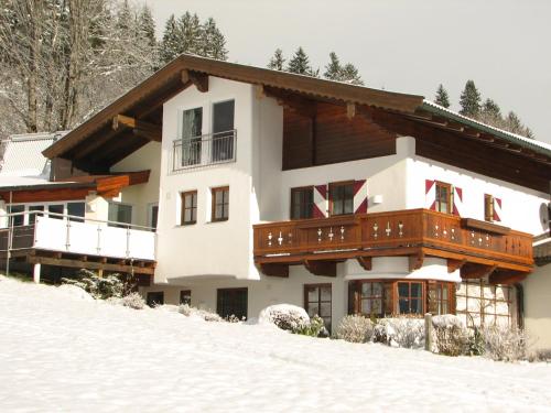 a house in the snow on a snow covered slope at Appartement Lotte Familie Grünberger in Brixen im Thale