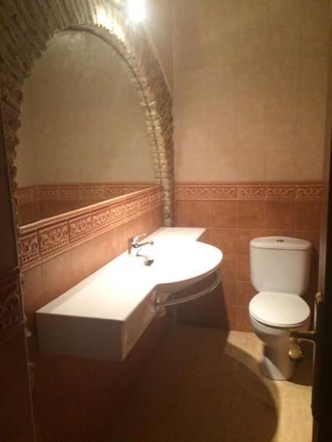 a bathroom with a sink and a toilet at Apartamentos Andrada in Casar de Cáceres