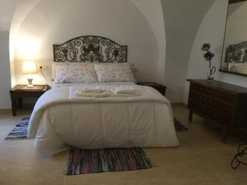 a bedroom with a large white bed with two pillows at Apartamentos Andrada in Casar de Cáceres