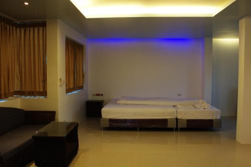 a bedroom with a bed and a couch at Suanmali Samui in Lamai