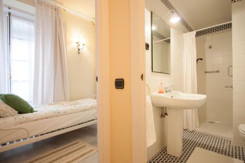 łazienka z łóżkiem i umywalką w obiekcie BOTANIC DUPLEX TERRACE 5 PAX w Sewilli