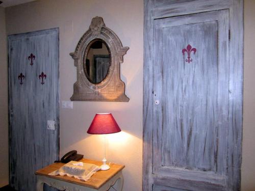 a table with a lamp and a mirror and a door at Hotel Boutique Balaitus in Sallent de Gállego
