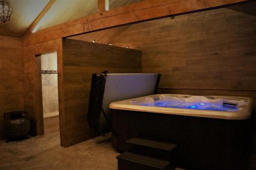 bañera en una habitación con pared de madera en Domaine des Marequiers le Gite Aigremoine, en Saint-Germain-du-Teil