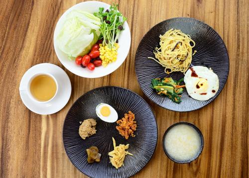 una mesa con platos de comida y una taza de café en Pokara Resort, en Jiaoxi