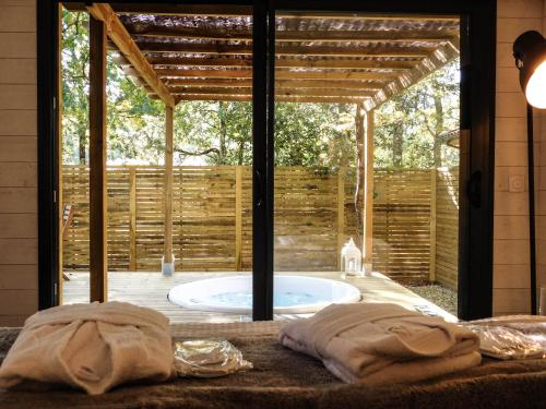 a jacuzzi tub in the middle of a patio at L'Haute en couleur cabanes spas in Audenge