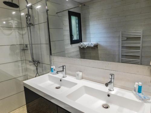 a bathroom with two sinks and a shower at L'Haute en couleur cabanes spas in Audenge