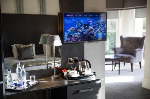 a hotel room with a tv on a wall at Keswick Country House Hotel in Keswick