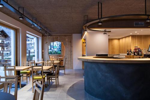 a restaurant with tables and chairs and a bar at Hotel Nevada in Bormio