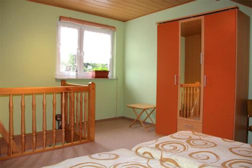 ヴァーレンにあるFerienhaus Waren SEE 7641のベッドルーム1室(オレンジ色のドア、窓付)