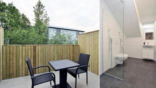 een badkamer met een tafel en stoelen en een toilet bij Lava Apartments & Rooms in Akureyri