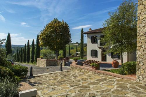 a stone walkway leading to a house with trees at Agriturismo Le Gallozzole in Monteriggioni