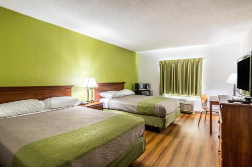 a hotel room with two beds and a flat screen tv at Motel 6-Petersburg, VA - Fort Lee in Petersburg