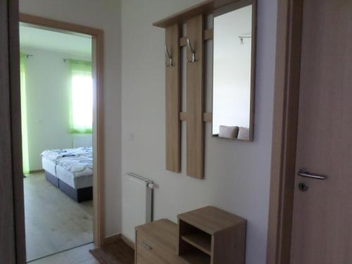 a mirror in a room with a bed and a bedroom at Lakóparki Apartman in Veszprém