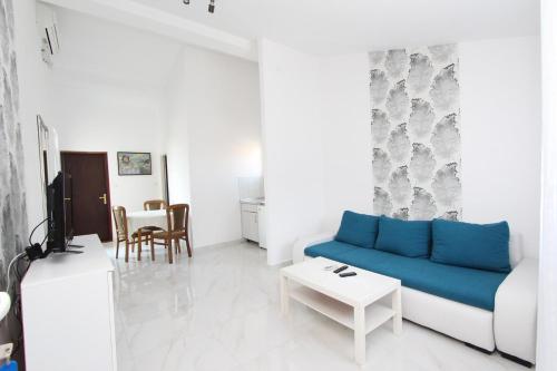 sala de estar con sofá azul y mesa en Apartments Sena, en Rovinj