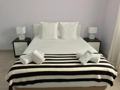 a bedroom with a large white bed with black and white stripes at Bluebelle by Pillow in Marbella