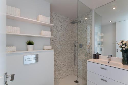 y baño con ducha acristalada y lavamanos. en Apartment front line, en Moraira