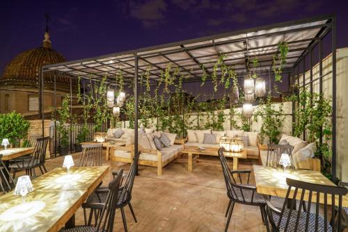 a patio with tables and chairs and a couch at The Valentia Cabillers in Valencia
