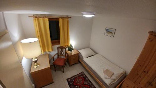1 dormitorio pequeño con 1 cama y 1 silla en Messezimmer Laatzen APO 2 en Hemmingen