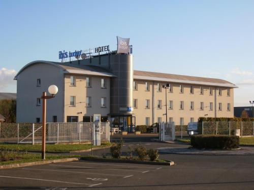 a building in a parking lot in front of a building at ibis budget Meung sur Loire in Meung-sur-Loire