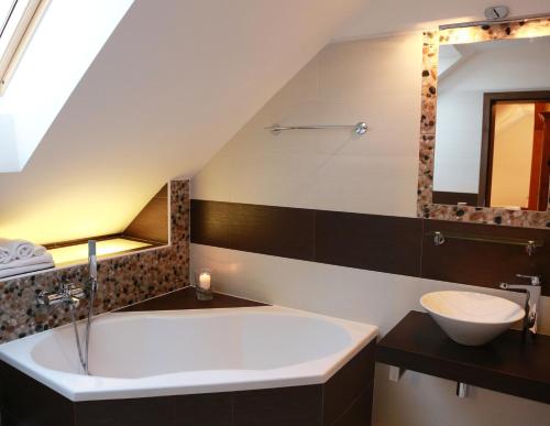 een badkamer met een groot bad en een wastafel bij Penzion Recall in Troskovice