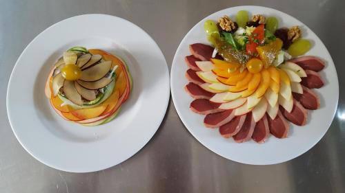 deux plaques blanches de nourriture sur une table dans l'établissement Auberge Lou Peyrol, à Montferrand-du-Périgord