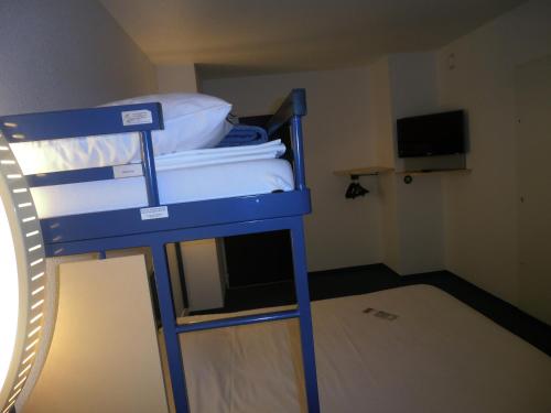 a blue bunk bed in a room with a television at ibis budget Meung sur Loire in Meung-sur-Loire