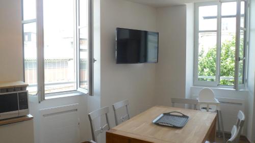 une salle à manger avec une table et une télévision murale dans l'établissement Les Halles 2, à La Rochelle
