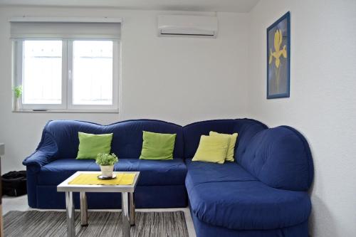 a blue couch in a living room with a table at Apartmani Balibeg in Sarajevo