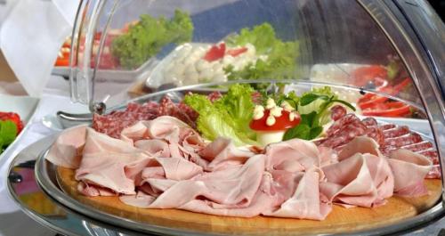 a plate of meat and vegetables on a table at Hotel Arabesco in Rimini