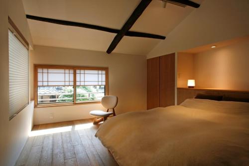 a bedroom with a large bed and a window at HANARé Gion in Kyoto