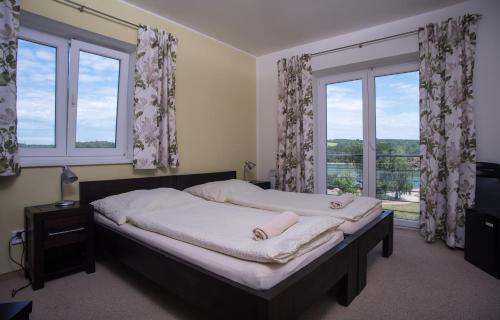 a bedroom with a large bed with a window at Penzion U Výra in Výrovice