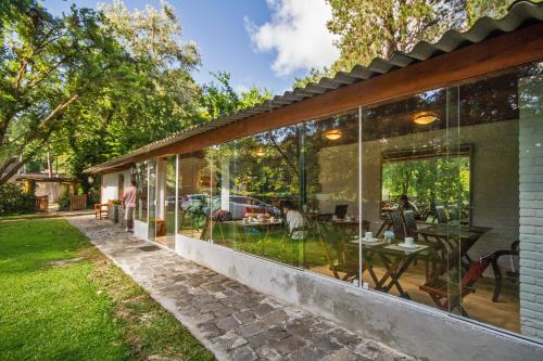 a glass extension of a house with a patio at Villa Vintage Campos - Piscina e opções de suites com hidromassagem in Campos do Jordão