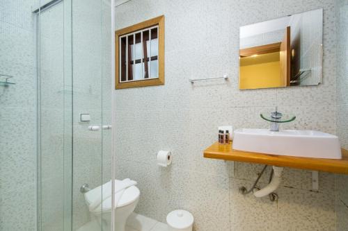 a bathroom with a toilet and a sink and a shower at Villa Vintage Campos - Piscina e opções de suites com hidromassagem in Campos do Jordão