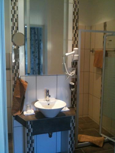 a bathroom with a sink and a shower at Hotel Cappuccino in Elze