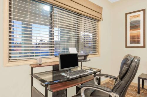 an office with a desk with a computer and two chairs at Days Inn by Wyndham Roswell in Roswell