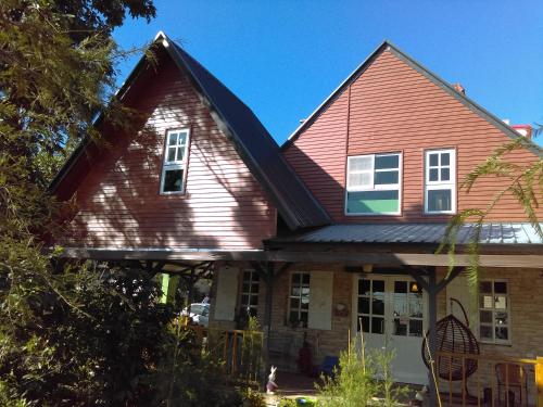 una casa roja con techo de gambrel en 啡藏幸褔小木屋羅東梅花湖Joy Home B&B, en Dayin