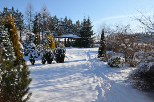 a snow covered path with a gazebo in the background at Willa Maciejka in Trybsz