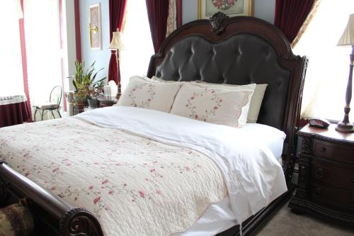 a bedroom with a large bed with a black headboard at The Gridley Inn B&B in Waterloo