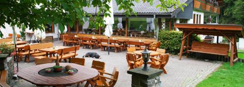 a patio with tables and chairs and a pig sleeping on the ground at Baunhöller-Mühle in Emmelshausen