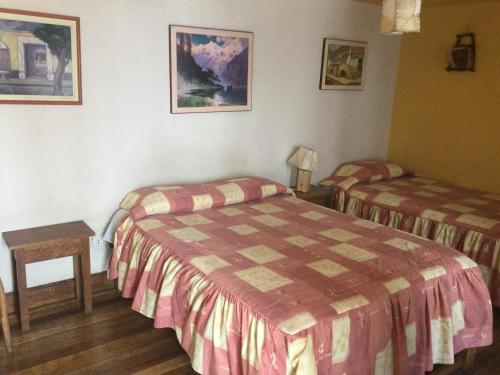 una camera d'albergo con due letti e un tavolo di Posada Junco y Capuli a Huancayo