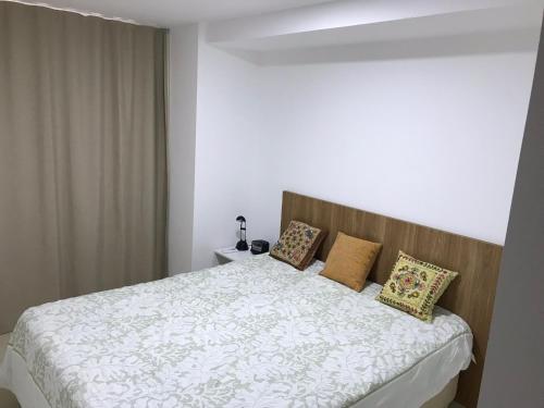 - une chambre avec un lit et des oreillers dans l'établissement O melhor 2 qtos da praia de Cabo Branco, à João Pessoa